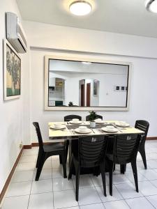 a dining room with a table and black chairs at Likas Square serviced apartment with garden view in Kota Kinabalu