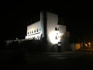a large white building with lights on it at night at El Castillo in Alcalá de Guadaira +6 photos