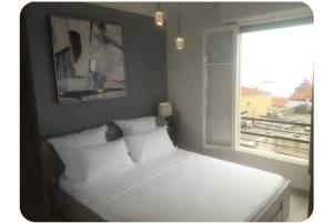 a bedroom with a white bed with a window at Stella apartment with Seaview on Montecarlo border in Beausoleil