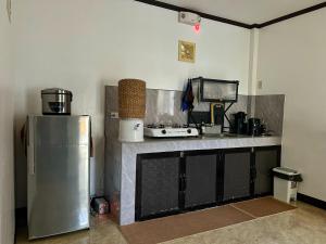 una cocina con fregadero y refrigerador en Frankies Island Home, en General Luna
