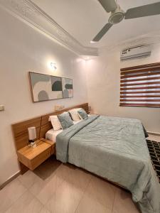 Un dormitorio con una cama grande y un ventilador de techo. en Résidence Sérénité -2 chambres Salon - vue sur mer, en Cotonou