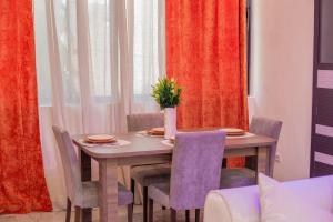 una mesa de comedor con sillas y un jarrón con una planta en Résidence Sérénité -2 chambres Salon - vue sur mer, en Cotonou 46 fotos más
