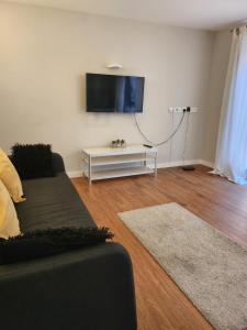 un salon avec un canapé et une télévision à écran plat dans l'établissement Luxury City Apartment in JQuarter Birmingham, à Birmingham
