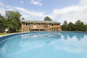 a large swimming pool in front of a house at Family Retreat with NEW POOL - Durham Upstairs Unit in Durham