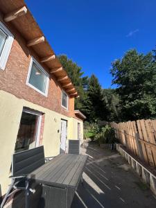a patio with a wooden table and a fence at Ferienhaus Abendsonne in Sebnitz