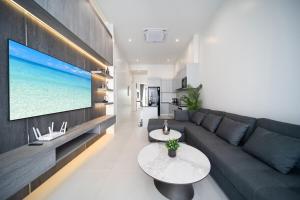 a living room with a couch and a flat screen tv at Luxury Modern Villa Phuket - Thala in Phuket
