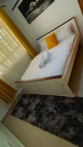a small bedroom with a bed with white sheets at Charme Home in Nanyuki