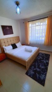 a bedroom with a large bed and a window at Charme Home in Nanyuki
