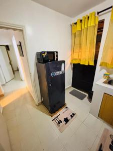 a kitchen with a small refrigerator in a room at Charme Home in Nanyuki