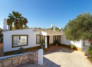 a white house with a tree and a fence at Oliveira by Vintage Travel in Guia