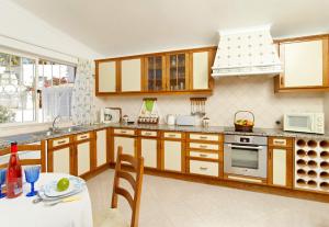 a large kitchen with wooden cabinets and a table at Oliveira by Vintage Travel in Guia