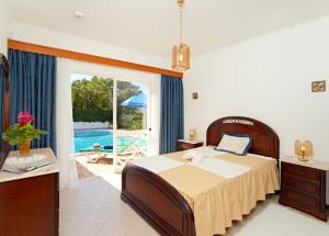 a bedroom with a bed and a view of a pool at Oliveira by Vintage Travel in Guia +8 photos