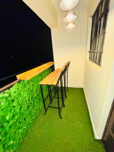 a room with a green floor with a bench in it at Charme Home in Nanyuki