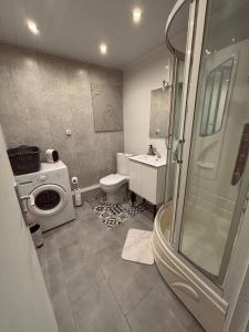 a bathroom with a shower and a toilet and a sink at Maison avec petite terrasse cosy 