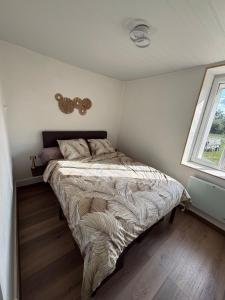 a bedroom with a bed in a room with a window at Maison avec petite terrasse cosy 