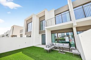 - une vue sur l'extérieur d'un bâtiment avec des chaises et de la pelouse dans l'établissement Luxury 4BR Villa Fully Furnished and Sleeps 11, à Dubaï