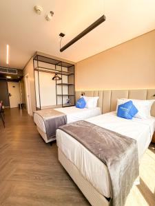 a hotel room with three beds in a room at Roomo Transamerica Goiânia Orion in Goiânia
