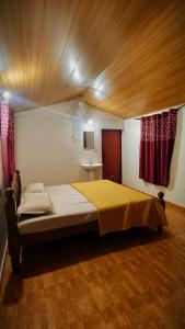 a bedroom with a large bed with a wooden ceiling at Madama Mudhouse Edenwood Retreats in Kanthalloor