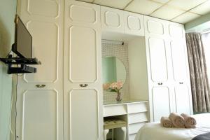 a bedroom with a bed and a tv and a mirror at Traditional 3-Bedroom Home- contractors and family in Dartford