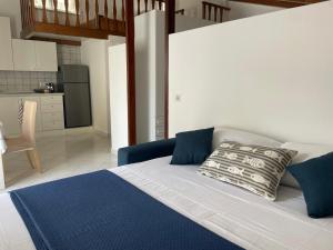 een slaapkamer met een bed met blauwe kussens en een keuken bij Sun drop in Sorrento +31 foto's