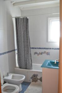 a bathroom with a toilet and a tub and a sink at Casa Hábitat - Habitaciones en casa compartida con baño privado in San Martín de los Andes +22 photos