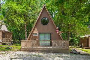 a house with a gambrel roof with a porch at Bar M Resort & Campground in Branson West