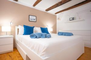 a bedroom with a white bed with blue pillows at Diso apartments in Naples