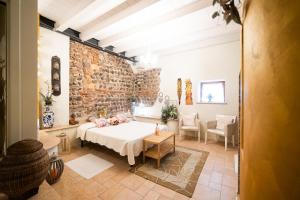 a bedroom with a bed and a brick wall at Residence Cà di Capri in Bussolengo