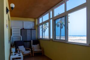 Una habitación con dos sillas y ventanas con vistas a la playa. en CasaBlanka, en Parque Holandes
