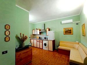 利沃诺Rombolino Guesthouse -Free Parking - Vicino al PalaLivorno "Modigliani Forum"的客厅里有一张沙发和一个厨房