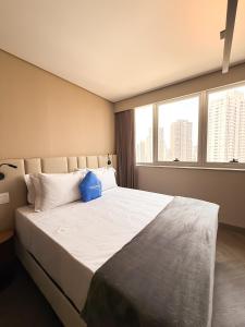 a bedroom with a large bed with a large window at Roomo Transamerica Goiânia Orion in Goiânia