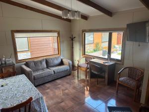 a living room with a couch and two windows at Portada de Magallanes in Punta Arenas