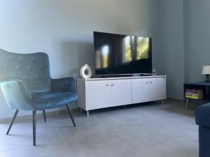 a living room with a tv and a chair at Willa Daisy in Jaskulin