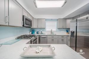 a kitchen with white cabinets and a tray on a counter at Mermaid's Place* 0.6 miles to beach* monthly disc in Destin