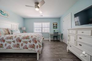 a bedroom with a bed and a dresser with a television at Mermaid's Place* 0.6 miles to beach* monthly disc in Destin