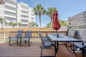 a patio with a table and chairs and an umbrella at Mermaid's Place* 0.6 miles to beach* monthly disc in Destin
