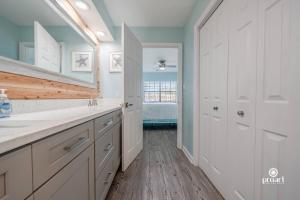 a kitchen with white cabinets and a bathroom with a sink at Mermaid's Place* 0.6 miles to beach* monthly disc in Destin +50 photos