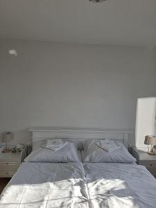 a white bed with two pillows on top of it at Apartman JAMI in Spišské Podhradie