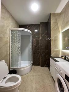 une salle de bain avec une douche, des toilettes et un lavabo dans l'établissement Tashkent City Apartments E2, à Tachkent