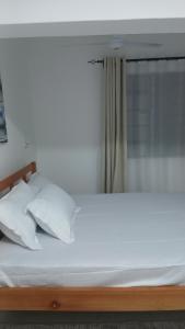 a bed with white sheets and pillows in a room at Imani stay cations Diani in Diani Beach +23 photos
