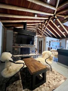 a living room with a table and chairs and a tv at Casa Temporada de Luxo no Lago Campo Mourão in Campo Mourão