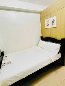 a bedroom with a large white bed in a room at Shore Bliss Staycation MOA in Manila