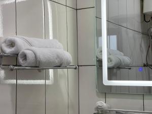 a pile of towels on a towel rack in a bathroom at C3 Resort Hotel Foumbot  +141 photos