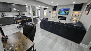 a living room with a large couch and a kitchen at 3 bdrm 3 bath bsmt Brampton Toronto, Sleeps 16 in Brampton