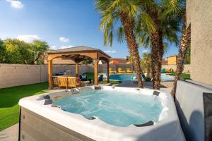 a hot tub in a backyard with a gazebo at Sleeps 16 Sport Court Heated Pool Putt Putt in Sun City