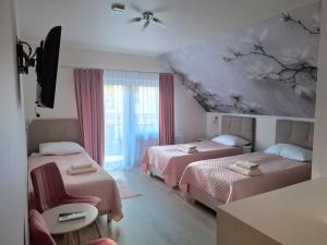 a bedroom with two beds and a ceiling with flowers on it at Restauracja -Zajazd trzech braci in Cieszyn