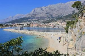 a beach with people on it with mountains in the background at Chill house in Makarska