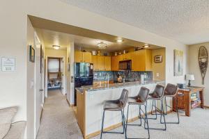 una cocina con una barra con tres taburetes en Snowblaze Condominiums C14, en Winter Park