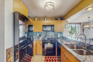 Una cocina con gabinetes de madera y un refrigerador de acero inoxidable. en Snowblaze Condominiums C14, en Winter Park 19 fotos más