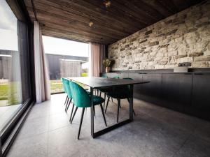 a dining room with a black table and blue chairs at La Rurée in Heure +23 photos